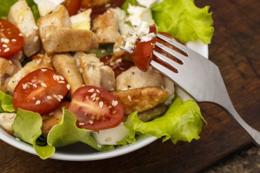 Tavuk, kiraz domates ve brynza yumuşak peynir ile Sıcak salata, zeytinyağı ile sos. Yakın çekim