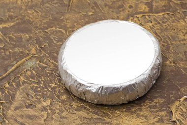 Cheese top hat in silver foil mockup. mockup for burger, butter and other products. Brown background. Product template clipart