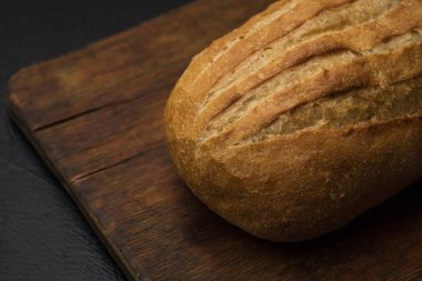 Eski bir kesme tahtasında taze ekmek. Metniniz için alan kopyalama