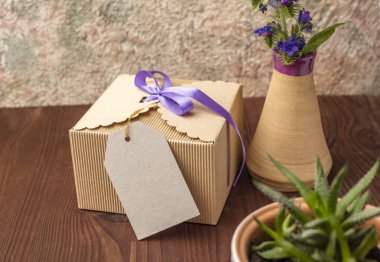 Metin için kraft karton bir etiketi ile ahşap bir masa üzerinde mikro oluklu Vintage hediye kutusu. Bayram günü kutlamalar kavramı, etkinlikler