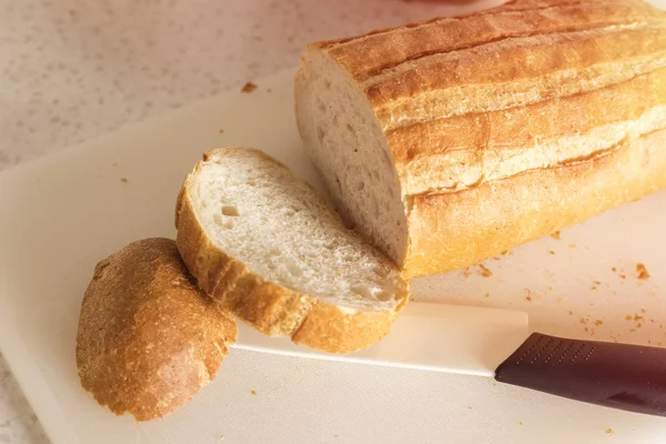Taze Dilimlenmiş Ekmek Rulo Seramik Bıçak Mutfak Masasında Plastik Kesme — Stok fotoğraf