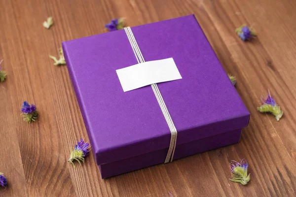 Violet gift box on a wooden table. Womans day, 8 march, wedding, dating, love concept. Top view