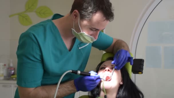 Молодая Женщина Сидит Стоматологическом Стуле Пока Мужчина Дантист Чинит Зубы — стоковое видео