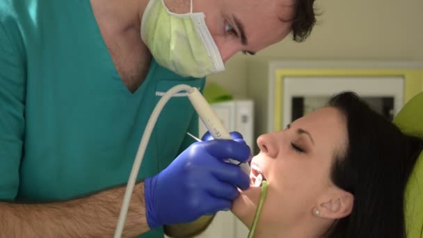 Młoda Kobieta Siedzi Fotel Dentystyczny Podczas Gdy Jej Mężczyzna Dentysta — Wideo stockowe