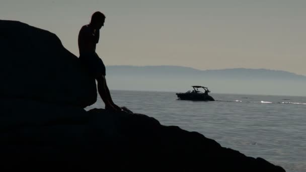 Silhouette Von Männern Auf Den Felsen Meer Während Das Boot — Stockvideo