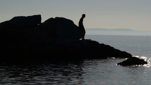 Silhouetten Van Jonge Man Rotsen Uit Zee Stijgt Van Een — Stockvideo
