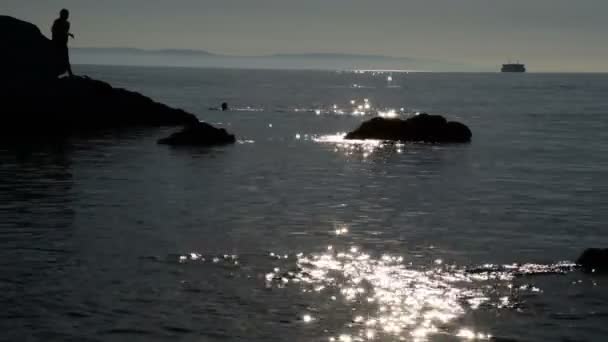 Silhouette Von Männern Auf Den Felsen Meer Während Das Boot — Stockvideo