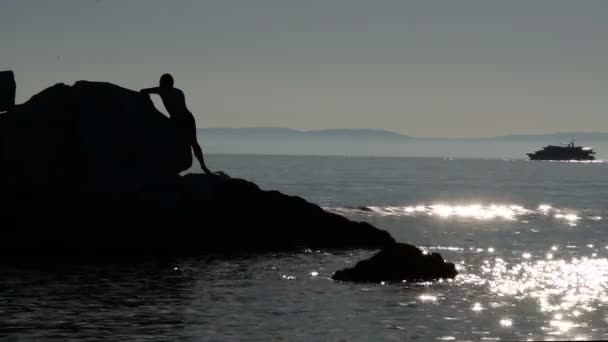 Silhouette Hommes Sur Les Rochers Dans Mer Tandis Que Bateau — Video