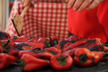 Izgarada pişirme kırmızı tatlı biber. Şef onları kapatır.