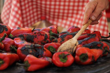 Izgarada pişirme kırmızı tatlı biber. Şef onları kapatır.