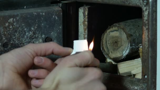 男性の手は発泡スチロールを起動し 木の丸太を暖炉に入れて — ストック動画
