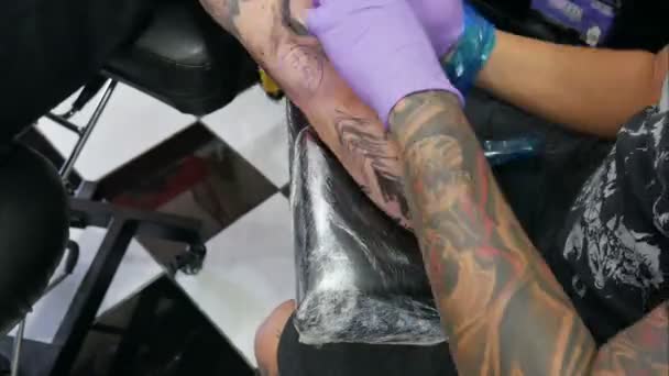 Mestre Tatuador Faz Uma Tatuagem Braço Cliente — Vídeo de Stock