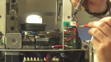 Tamir makinesinde çalışan elektronik mühendisinin elleri - Multimetre test cihazı ile elektrikçi ölçümleri