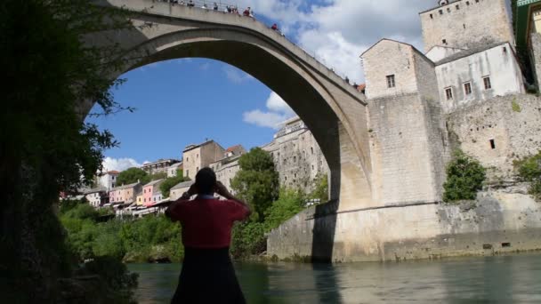 Turisten Med Sin Mobil Spelar Den Ombyggda Gamla Bron Mostar — Stockvideo