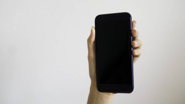 İzole kadın el ile siyah ekran bir telefon tutarak