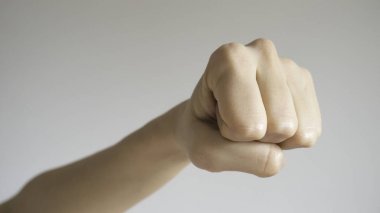Kadının yumruğu açık gri arka planda izole edilmiş. Kameraya yaklaş. Ön görünüm.