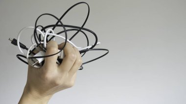 İzole arka planda bir kadının elinde siyah ve beyaz kablolar - yakın