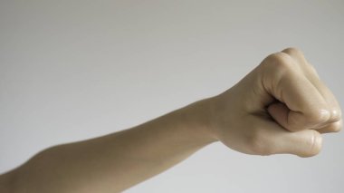 Kadının yumruğu açık gri arka planda izole edilmiş.. 