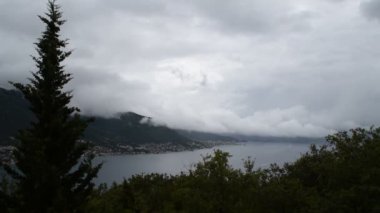 Beyaz bulutlar dağları ve Karadağ'ın Kotor Körfezi'ni kapladı. Fırtınadan birkaç dakika önce.