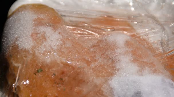 塑料包装中的冷冻肉正在解冻 — 图库视频影像