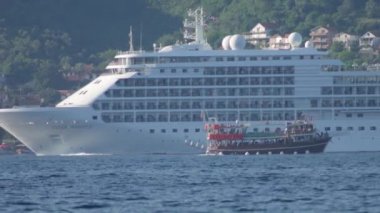 Silver Whisper Silversea yolcu gemisi Ahşap çift katlı bir tekneile geçiyor - Ağustos 2019, Kotor bay (Boka Kotorska), Karadağ.