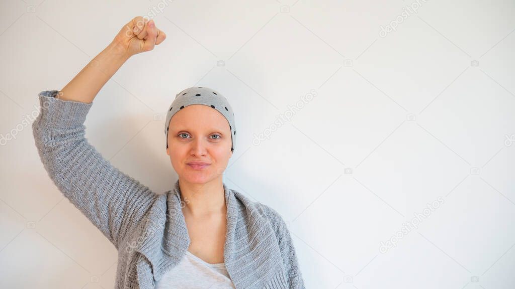 Portrait of female cancer survivor without eyebrows. Happy cancer survivor after successful chemotherapy.  Female hairless fight against cancer no white background. Negative space. Copy space for text.