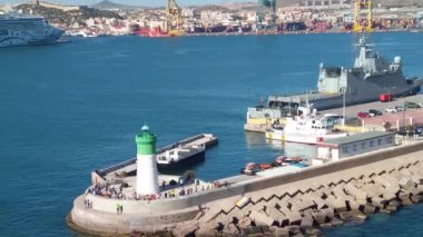 İspanya, Mayıs 2019 - Kartagena limanında yeşil-beyaz deniz feneri ve arka planda NCL Norveç Yıldızı yolcu gemisi.