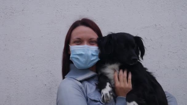 Uma Cadela Feliz Com Uma Máscara Cirúrgica Seu Rosto Acaricia — Vídeo de Stock