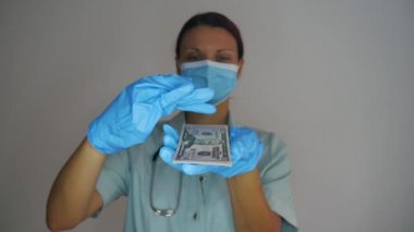 Tıbbi maskeli ve lateks eldivenli bir kadın doktor para yağdırıyor. Tıpta rüşvet ve yolsuzluk.