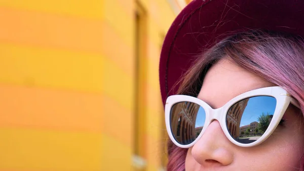 A reflection of a high school building in Mostar in the sunglasses of a young woman. United World College Gymnasium building. Now popularly referred to as Stara gimnazija, Old Gymnasium, Mostar, Bosnia-Herzegovina