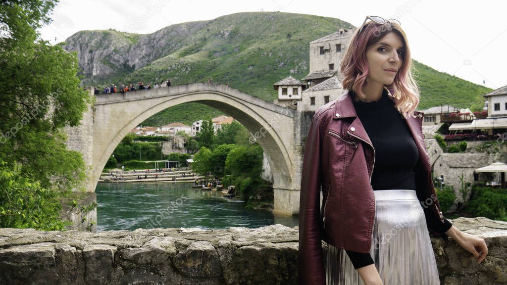 Woman in front of river Neretva and The Old Bridge in Mostar, Bosnia and Herzegovina.