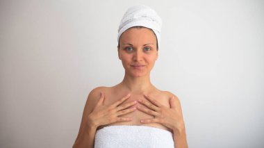 Kafası ve vücudu temiz beyaz havlulara sarılı beyaz bir kadın. Güzellik Kozmetikleri ve Spa Tedavi Konsepti.