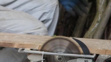 Erkeklerin eldivenli ellerinden üçü yakacak odun kesiyor ve kovalara koyuyor.. 