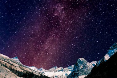 Gecenin karanlığında dağların üzerinden Samanyolu.