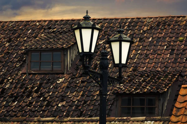 老灯饰在老镇 红色屋顶与窗口在背景上 — 图库照片