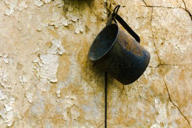 Bir kırsal, felaket arka plan yanmış bir evde bir ocakta metal Kupası