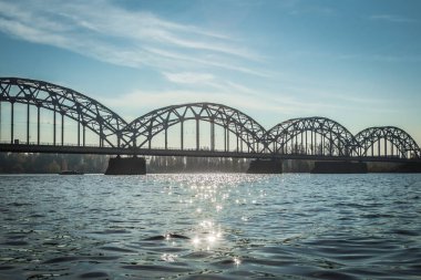 Riga'da Daugava Nehri güneşli bir günde, manzara Ekim ayında sonbaharda Demiryolu Köprüsü