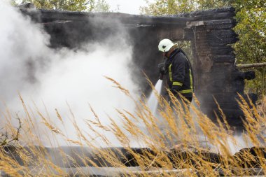 İtfaiyeciler de yangın söndürme çalışmalarını köy evi Mengele Letonya 05.10.2018 yok