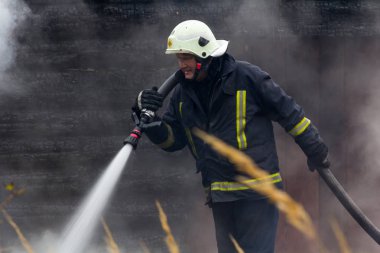 İtfaiyeciler de yangın söndürme çalışmalarını köy evi Mengele Letonya 05.10.2018 yok