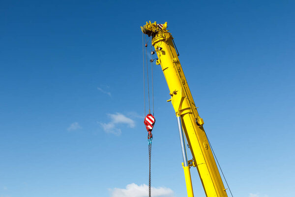 Mobile crane hook with chains, industrial background