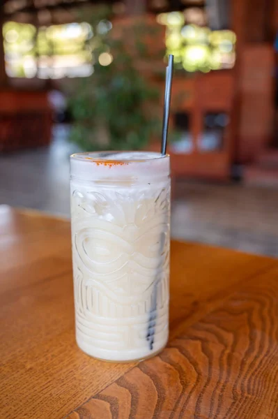 Kafedeki ahşap bir masada buzlu soğuk süt içeceği.