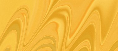 Sarı ve turuncu tonlarda dalgalı çizgilerle dolu, kumlu bir yüzeyin soyut bir görüntüsü..