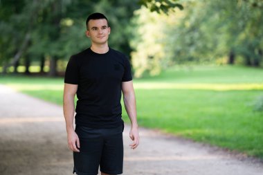 Gri spor ayakkabılı adam dışarıda yürüyor.