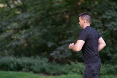 Gri spor ayakkabılı adam dışarıda yürüyor.