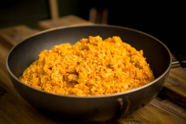 Siegen, Almanya - 08.27.2025. Sebzeli ev yapımı pirinç ve tavada et. Sadece editör kullanımı.