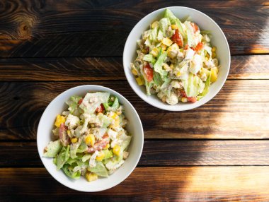 Tahta bir masada kaselerde servis edilen taze sebze salatası. Sağlıklı bir ev yapımı vitamin tabağı..