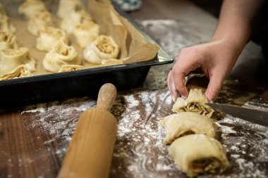 Tarçınlı rulo dilimleri pişirme tepsisine yerleştiriyorum. Ev yapımı pasta hazırlama.