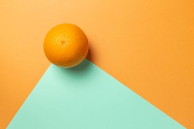 İki renkli arka planda turuncu. Düz narenciye. Geometrik konsept.