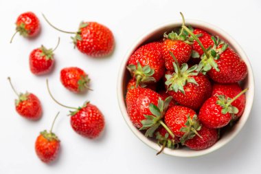 İzole edilmiş beyaz kasede taze çilekler.