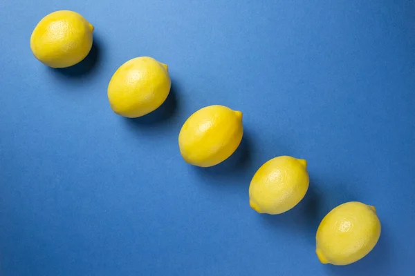 Lemons on the blue background. Flat lay.